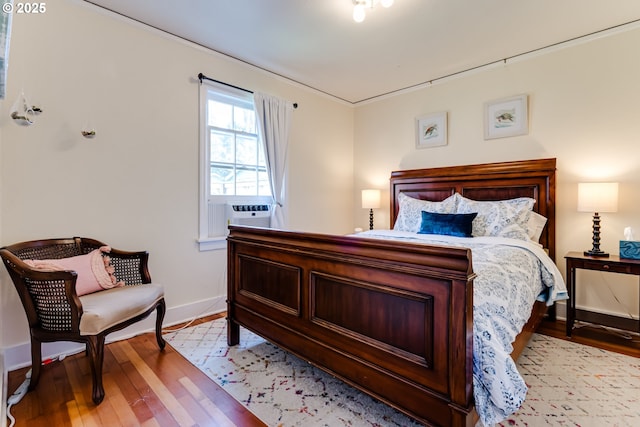 bedroom with baseboards, light wood-style floors, and cooling unit