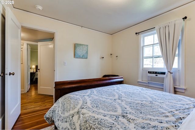 bedroom featuring wood finished floors and cooling unit