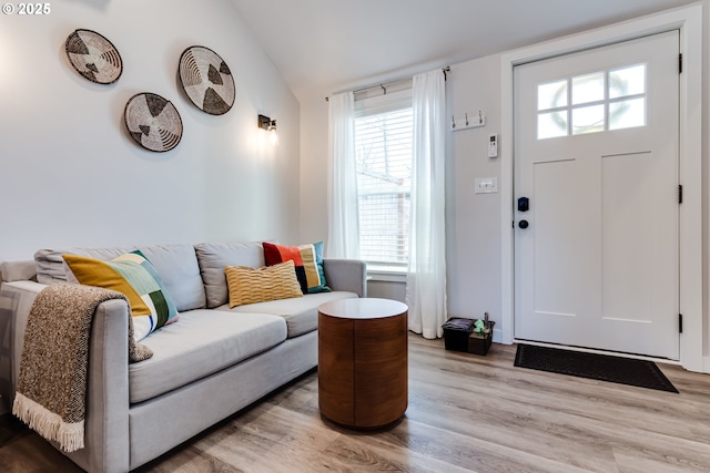 entrance foyer featuring light wood finished floors, lofted ceiling, and a healthy amount of sunlight