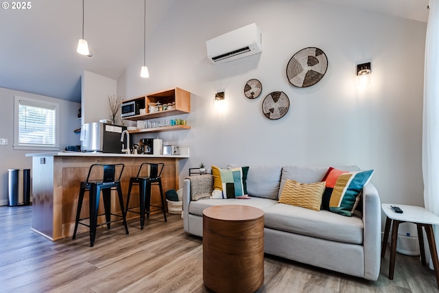 living room with high vaulted ceiling, a wall mounted AC, and light wood-type flooring