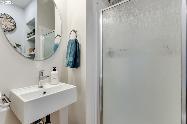 bathroom with a sink and a shower stall