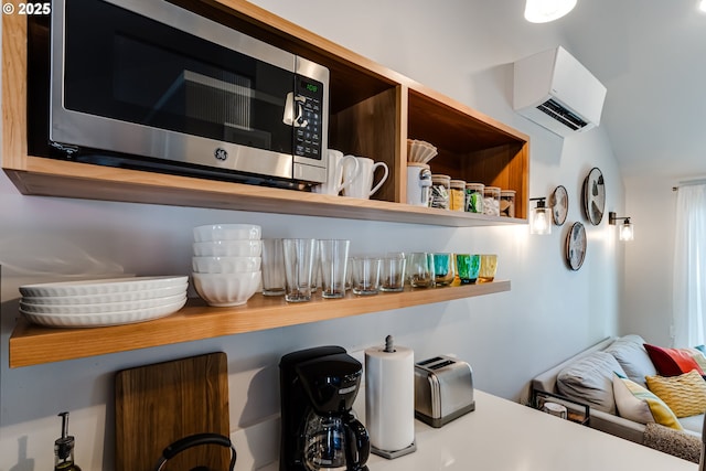 room details featuring a wall mounted air conditioner, stainless steel microwave, and open shelves