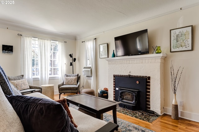 living room featuring a fireplace, wood finished floors, and baseboards