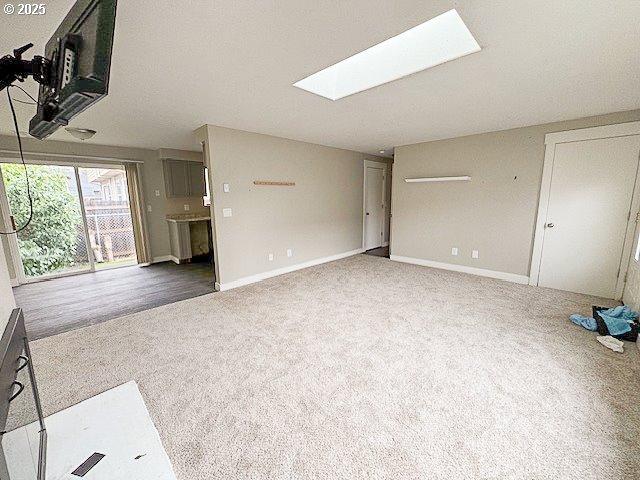 carpeted living room with a skylight