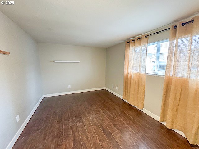 empty room with dark hardwood / wood-style flooring