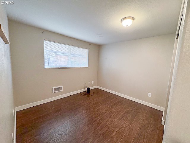 spare room with dark hardwood / wood-style floors