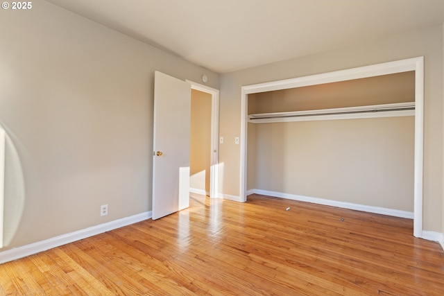 unfurnished bedroom featuring light wood-type flooring and a closet