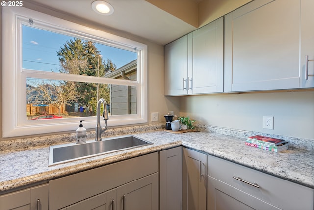 kitchen with light stone counters and sink