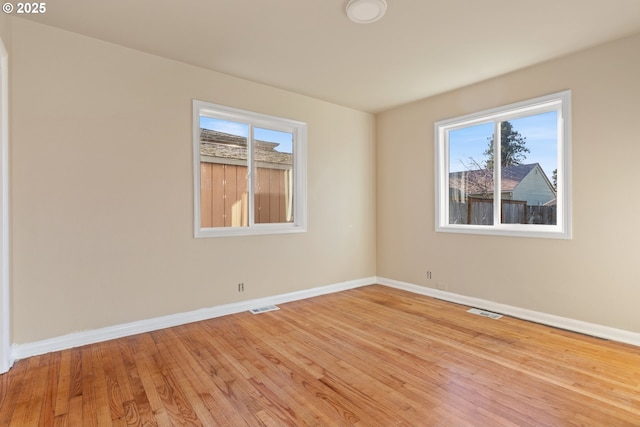 unfurnished room with a healthy amount of sunlight and light wood-type flooring