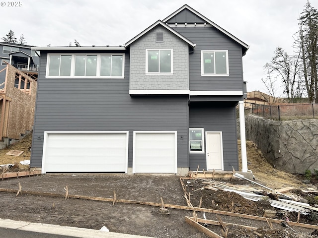 back of house featuring a garage, driveway, and fence