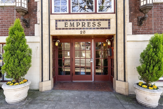 entrance to property featuring french doors and brick siding