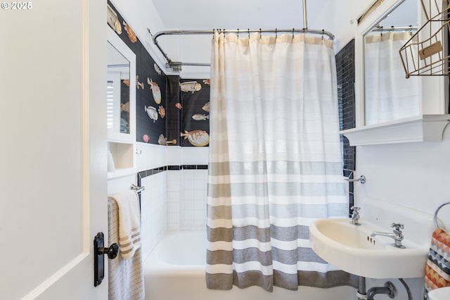 bathroom with shower / tub combo and a sink