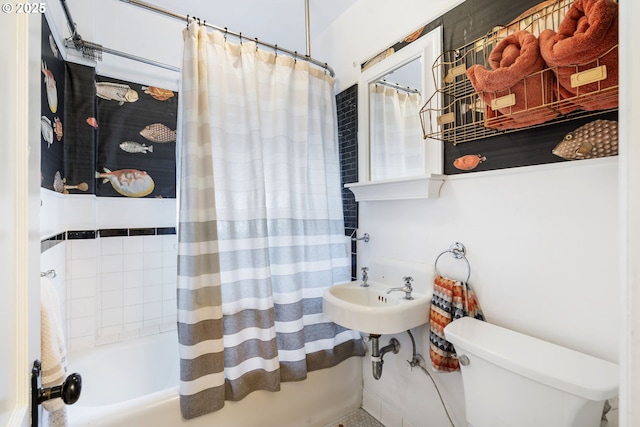 full bathroom with toilet, shower / bathtub combination with curtain, and a sink