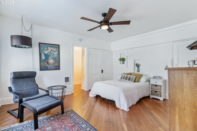 bedroom featuring visible vents, ceiling fan, baseboards, and hardwood / wood-style flooring