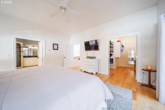 bedroom featuring light wood-style flooring, a spacious closet, baseboards, and connected bathroom