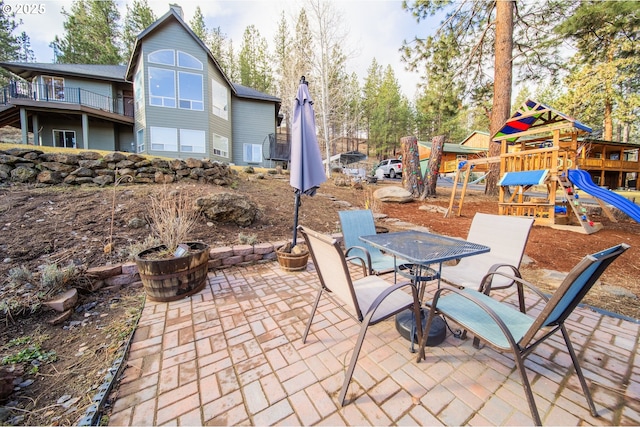 view of patio with outdoor dining space and a playground