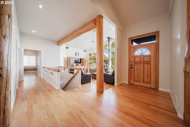 entryway with recessed lighting, vaulted ceiling with beams, light wood-style flooring, and baseboards