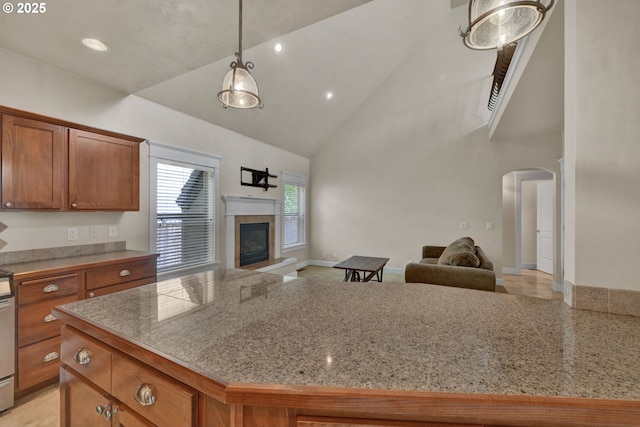 3435 Meadow View Dr, Eugene, OR 97408 - kitchen with open floor plan, arched walkways, brown cabinetry, high vaulted ceiling, and hanging light fixtures