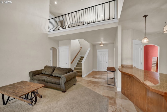 3435 Meadow View Dr, Eugene, OR 97408 - living room featuring arched walkways, stairway, a towering ceiling, and baseboards