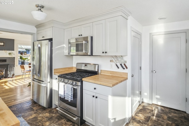 7615 SE 66th Ave, Portland, OR 97206 - kitchen with stainless steel appliances, butcher block counters, and white cabinetry