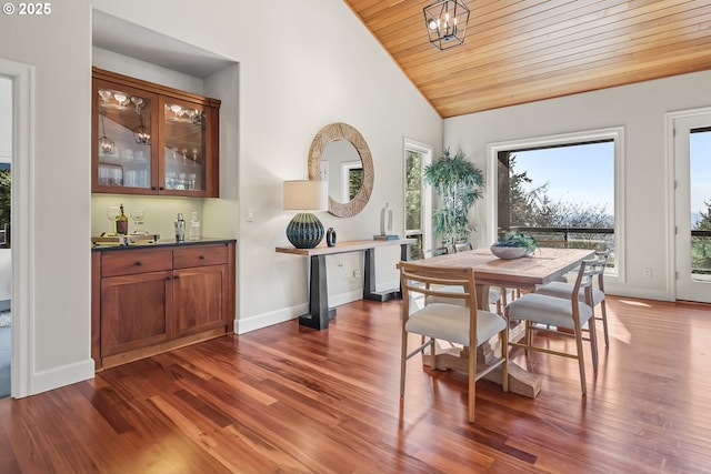 dining room with dark wood-type flooring, baseboards, a chandelier, wood ceiling, and vaulted ceiling