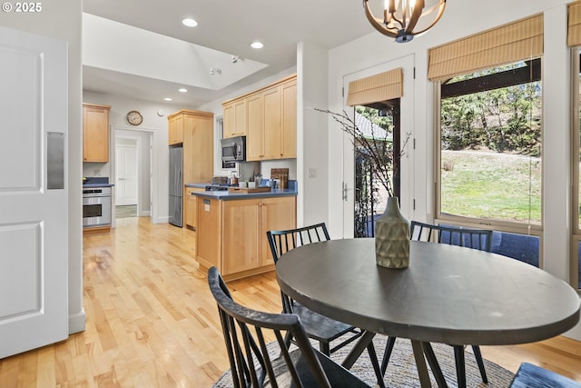 dining room with light wood-style flooring, recessed lighting, and a chandelier