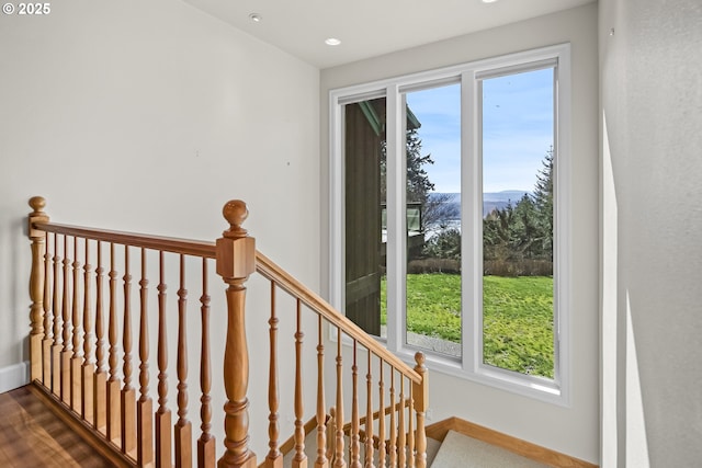 staircase featuring baseboards and wood finished floors