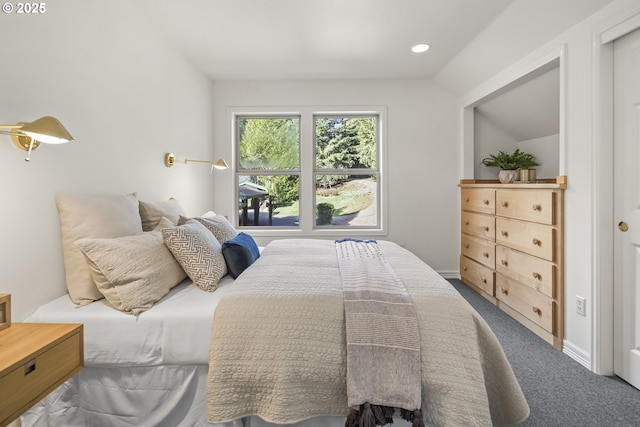 bedroom with lofted ceiling, baseboards, and dark carpet