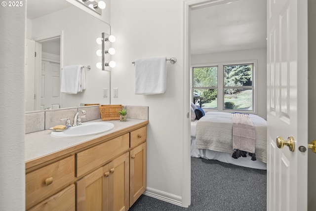 bathroom with vanity, ensuite bathroom, and baseboards