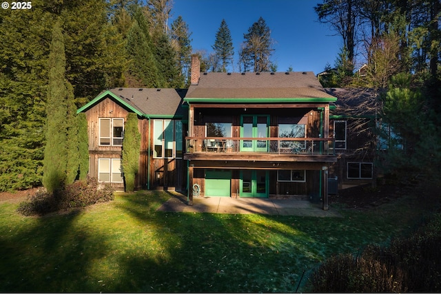 back of house featuring a deck, a lawn, a chimney, and a patio