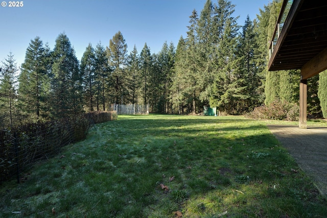 view of yard with fence and a wooded view