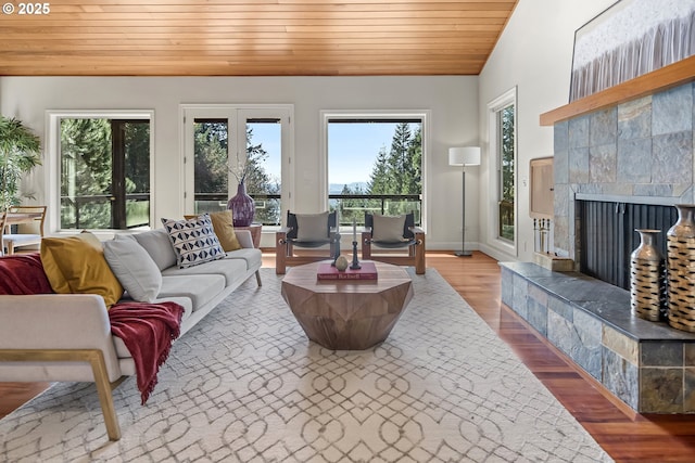 sunroom featuring wood ceiling, vaulted ceiling, and a tile fireplace