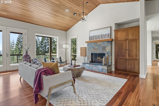 living area featuring baseboards, wood ceiling, a fireplace, wood finished floors, and high vaulted ceiling