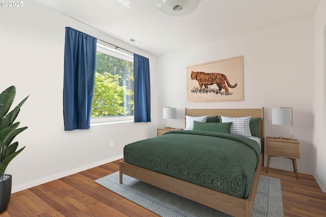bedroom with wood finished floors and baseboards