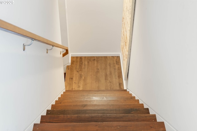 stairs featuring wood finished floors and baseboards