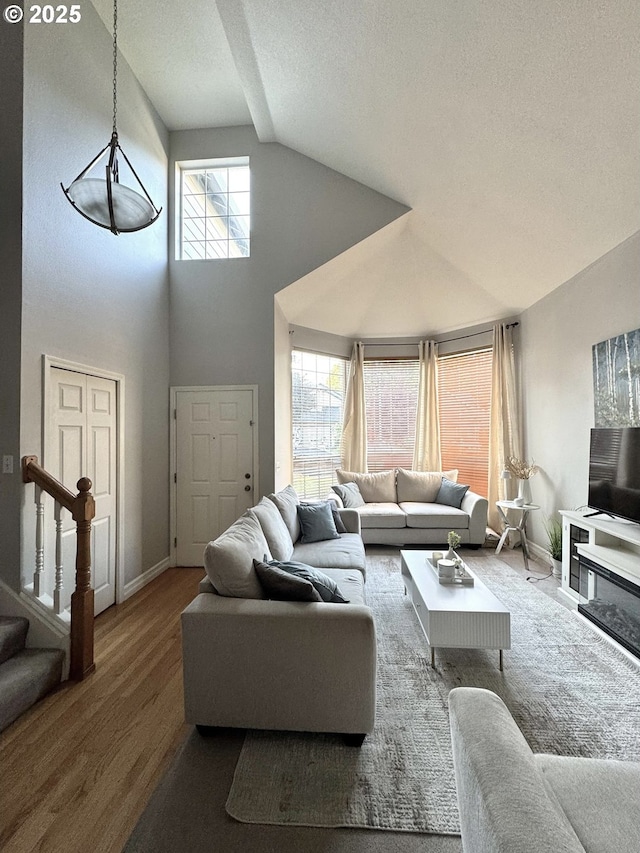 1556 NE 27th Ter, Gresham, OR 97030 - living room featuring plenty of natural light, wood finished floors, baseboards, stairs, and high vaulted ceiling