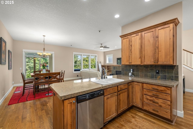 14746 SW 148th Ter, Tigard, OR 97224 - kitchen with stainless steel dishwasher, brown cabinetry, a peninsula, dark wood-style flooring, and decorative backsplash
