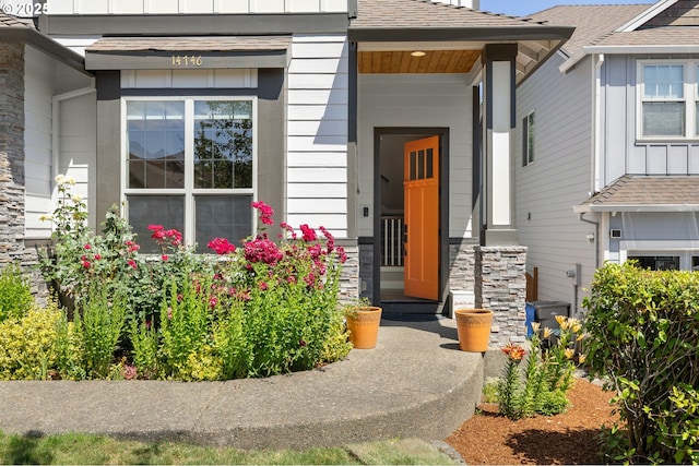 14746 SW 148th Ter, Tigard, OR 97224 - view of exterior entry with stone siding, a shingled roof, and board and batten siding