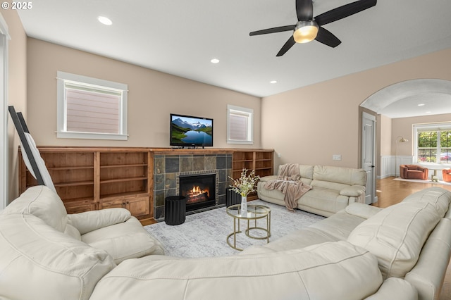 14746 SW 148th Ter, Tigard, OR 97224 - living room with arched walkways, ceiling fan, wood finished floors, a tiled fireplace, and recessed lighting