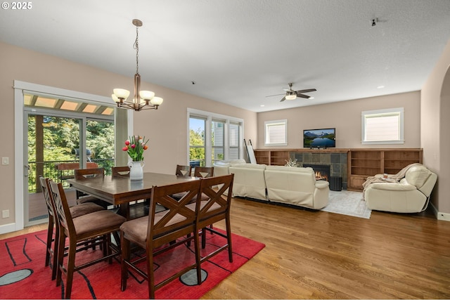 14746 SW 148th Ter, Tigard, OR 97224 - dining space with a tiled fireplace, light wood-style floors, ceiling fan, and healthy amount of natural light