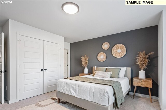 bedroom featuring light colored carpet and a closet