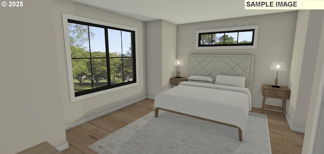 bedroom featuring multiple windows and light hardwood / wood-style flooring