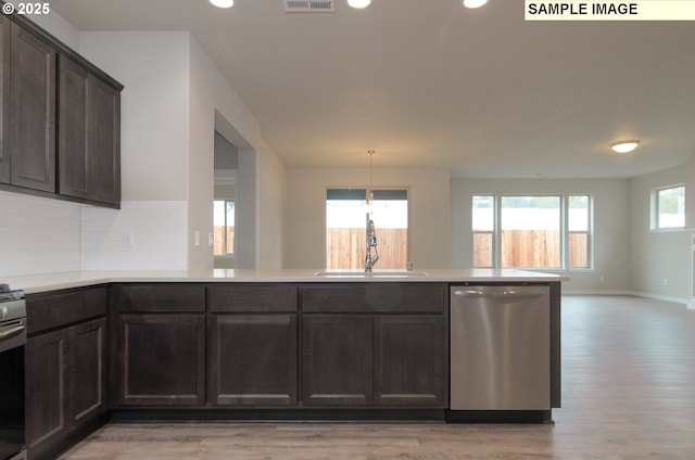 kitchen featuring stainless steel appliances, dark brown cabinets, tasteful backsplash, and sink