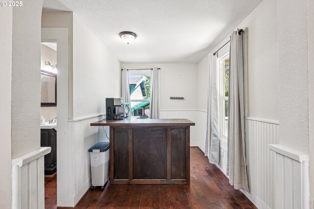 office area with a wainscoted wall and dark wood-style floors