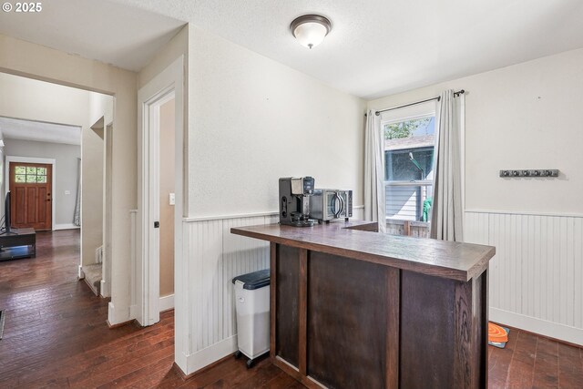 office featuring dark wood finished floors and a wainscoted wall