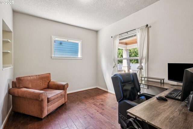 office area with baseboards, a textured ceiling, and hardwood / wood-style flooring