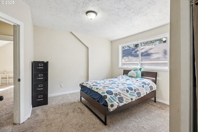 carpeted bedroom featuring baseboards and a textured ceiling