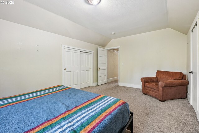 carpeted bedroom with baseboards, lofted ceiling, and a closet