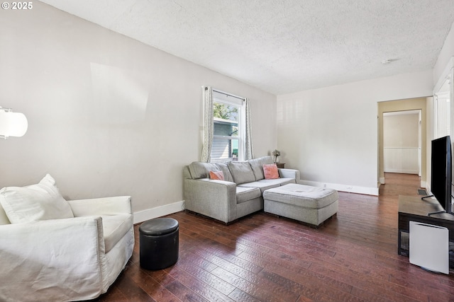 living room with baseboards, hardwood / wood-style flooring, and a textured ceiling