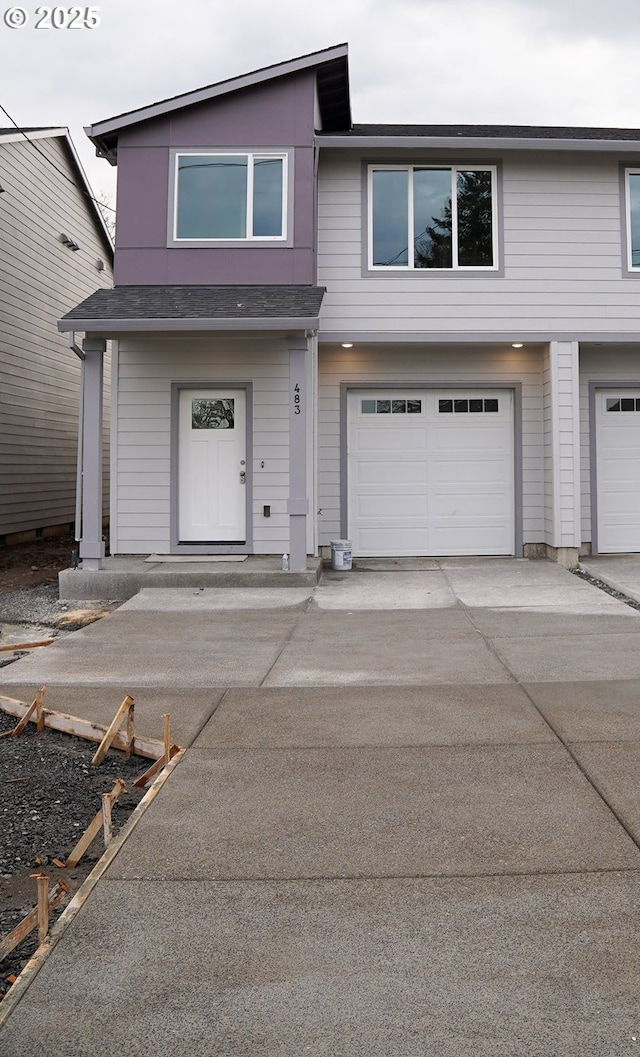 townhome / multi-family property featuring driveway and an attached garage